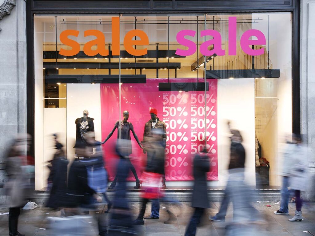 Store shopping window with a banner advertising a sale.