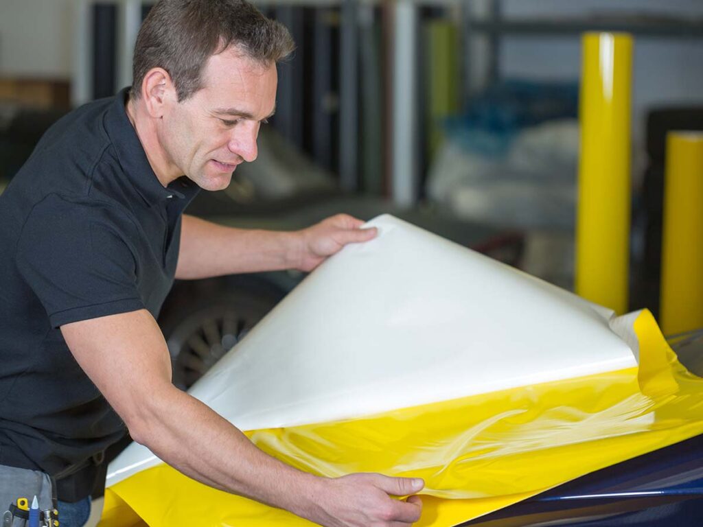 professional preparing a car wrap for a company